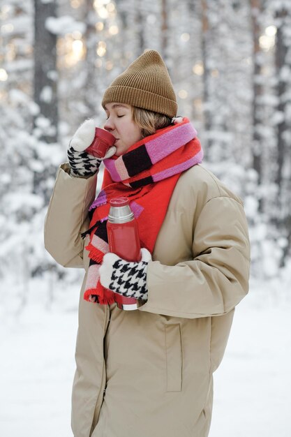 Woman drinking tea at picnic outdoors