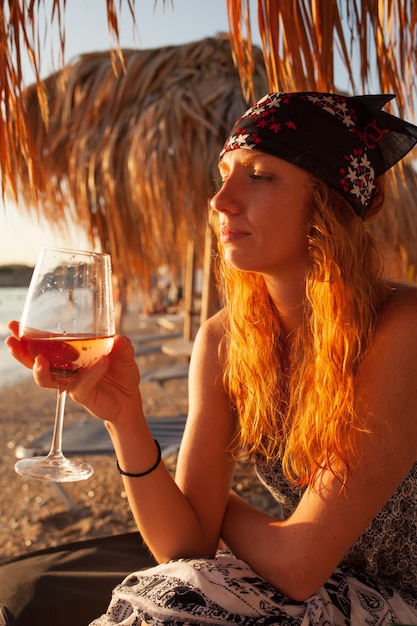 A woman drinking wine on the beach