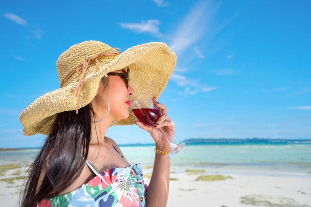 Woman drinking wine in glass at beach