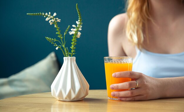 woman drinks orange juice in a cafe closeup