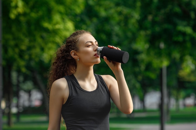 Woman drinks water after running