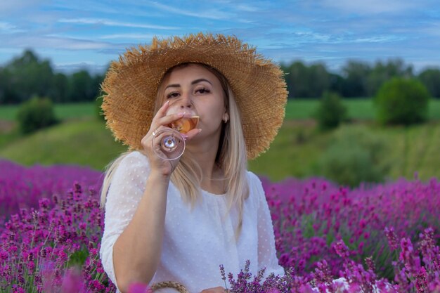 A woman drinks wine in a lavender field Selective focus Food