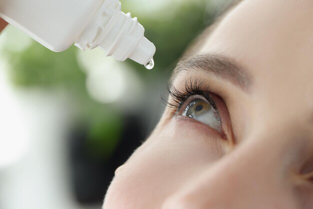 Photo woman drips eye drops into eye for allergies closeup