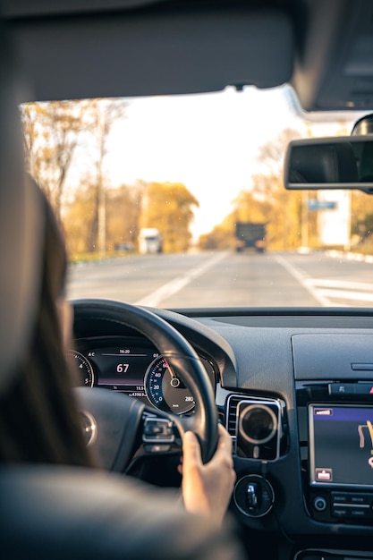 Woman driver hands on steering wheel inside car