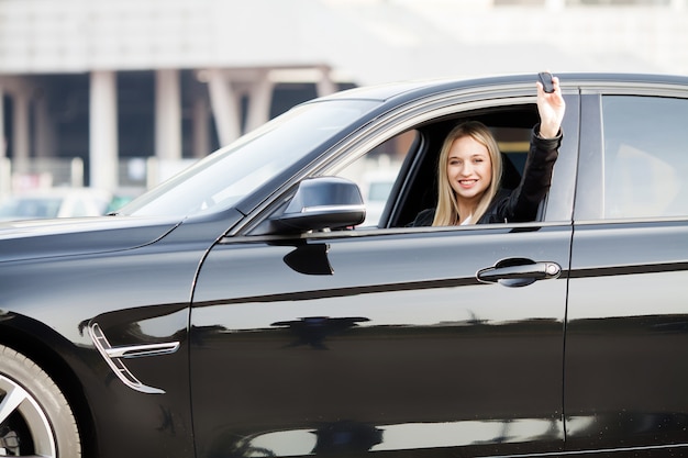 Woman Driver Holding Car Keys siting in Her New Car