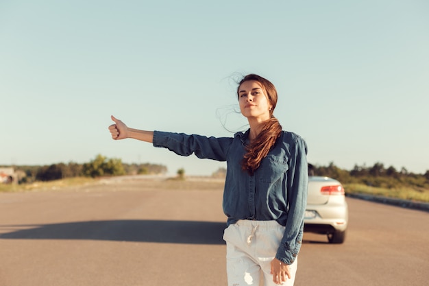 Woman driver near a broken car, A car on a country road, a woman catches a ride