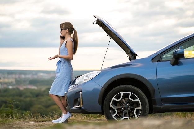 Foto driver della donna che riposa vicino alla sua automobile