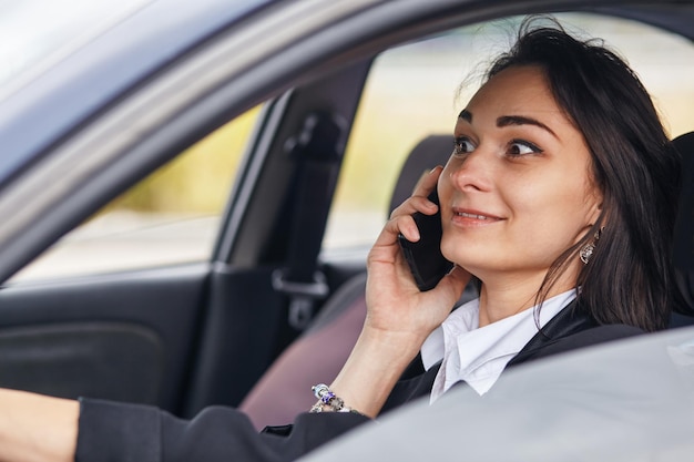 A woman driver using her mobile phone while driving car