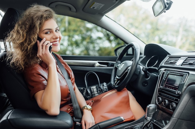 Woman driver using a smart phone in car