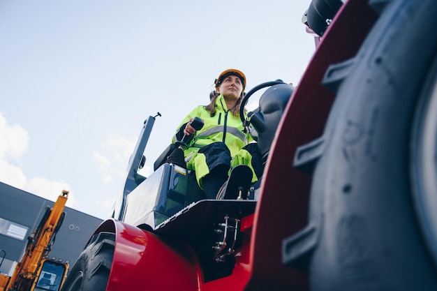 Photo woman driving construction vehicle against sky