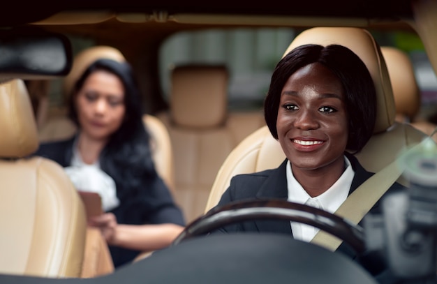사진 뒷좌석에 그녀의 고객과 함께 그녀의 택시를 운전하는 여자