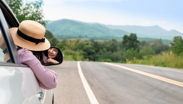 道路上の運転の女性が車で旅行をリラックスします。