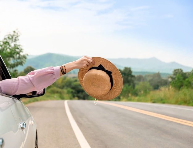 Donna che guida su strada il viaggio in auto si rilassa