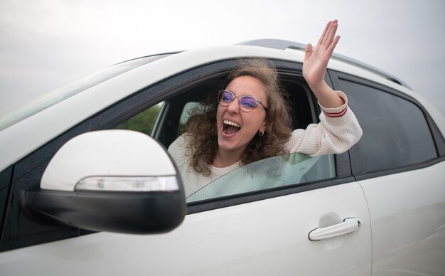 Woman driving very angry sticking her arm out the window in a traffic jam