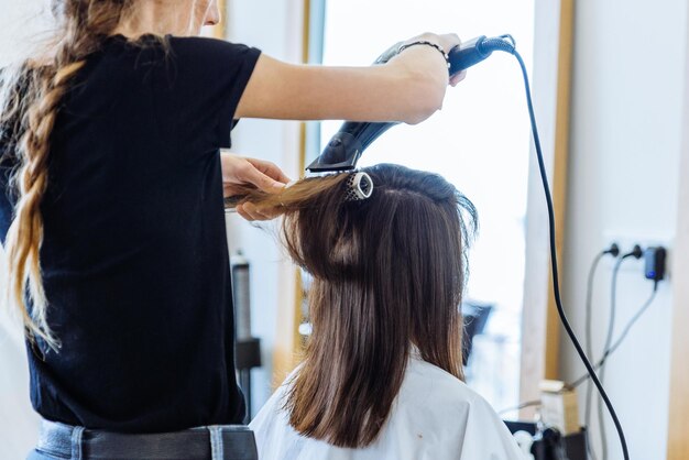 Woman drying hair in hair salon