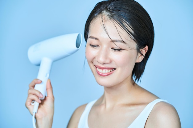 A woman drying her hair with a hair dryer