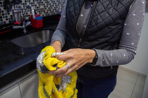 Женщина вытирает руки после мытья посуды