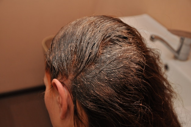 Photo woman dyeing her hair at the salon