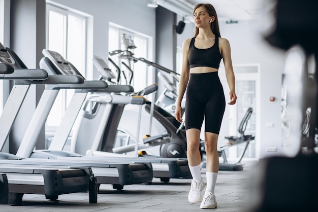 Woman in earphones listening to music at the gym