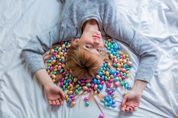 Woman and Easter candy in a bed