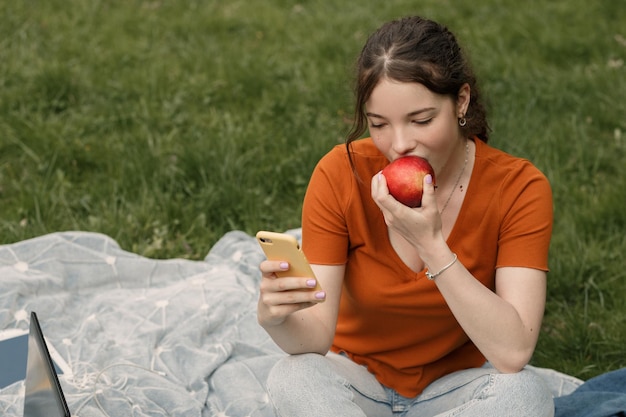 Фото Женщина ест яблоко в парке