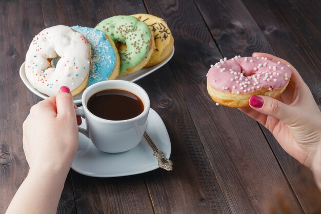 Woman eat donut and drink coffee