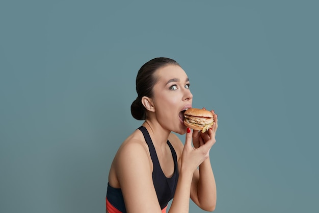 女性はハンバーガーを食べるハンバーガーと彼女の手の女の子のハンバーガー