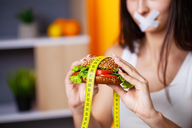 여자는 과체중을 유발하는 해로운 음식을 먹습니다.