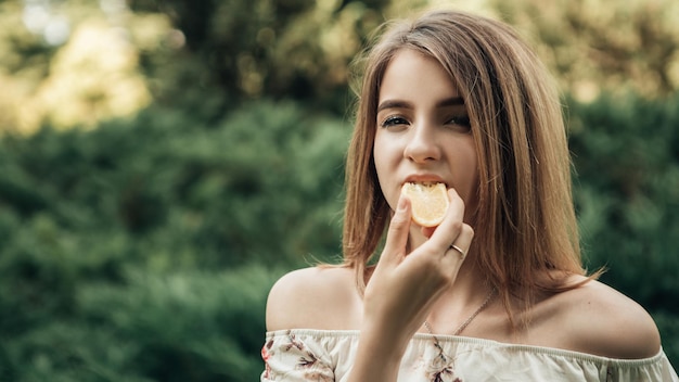 女性は外でレモンを食べる