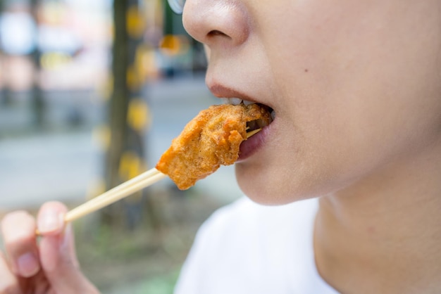 Woman eat with piece of the crispy chicken