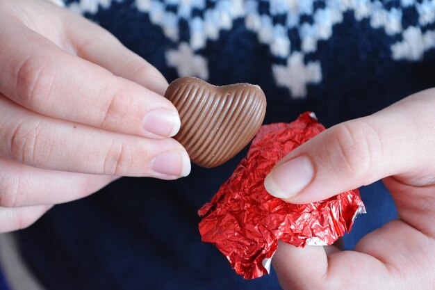 Фото Женщина ест шоколадное сердце в день святого валентина