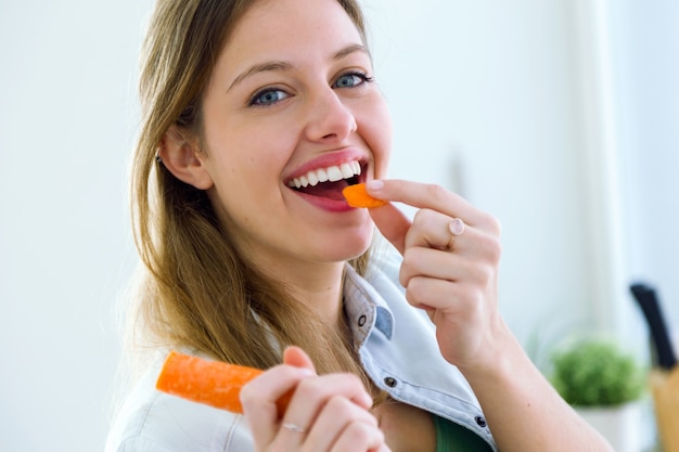 Woman eating carrot