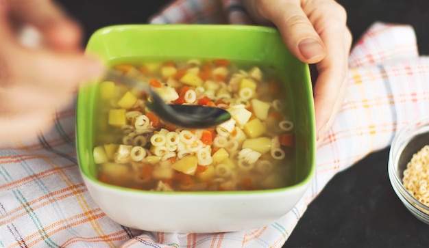 Woman eating fresh homemade chicken soup at table