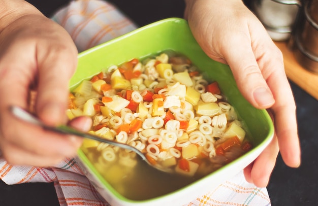 Woman eating fresh homemade chicken soup at table