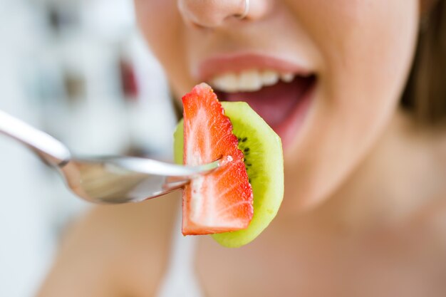 "Woman eating fruit salad"