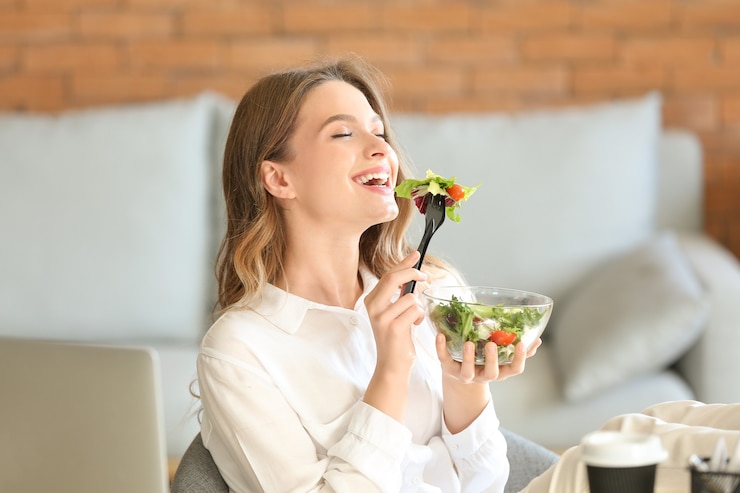 Photo woman eating healthy vegetable salad in office
