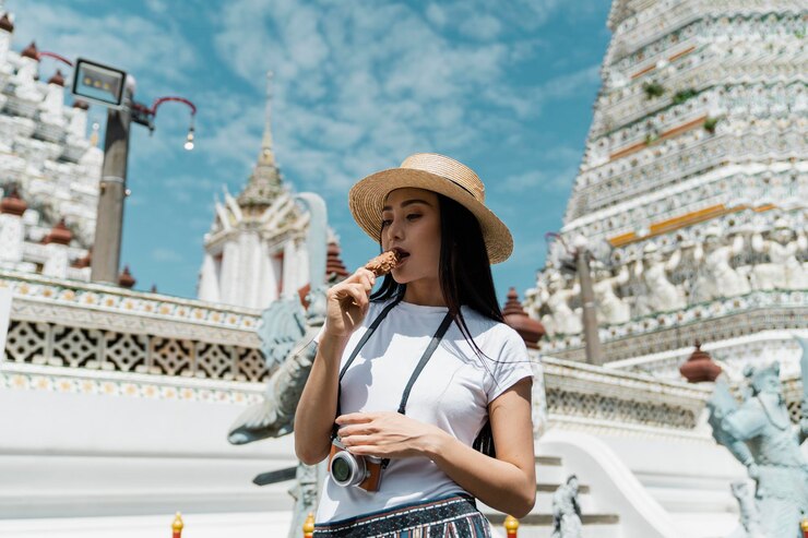 Photo 寺院の前でアイスクリームを食べている女性