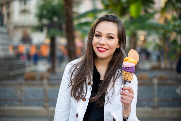 Donna che mangia un cono gelato all'aperto