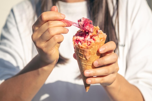 Foto donna che mangia il gelato in un primo piano del cono della cialda