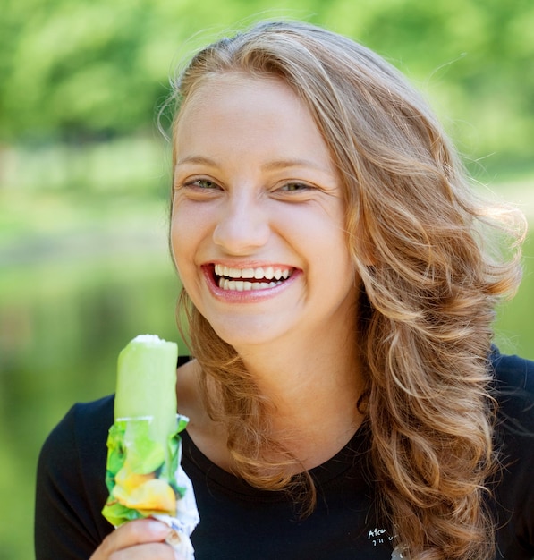 Woman eating icecream sunny day outdoors