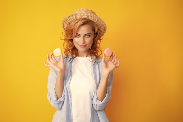 Foto donna che mangia un amaretto bella donna rossa in cappello di paglia estiva che mangia dolci amaretti francese