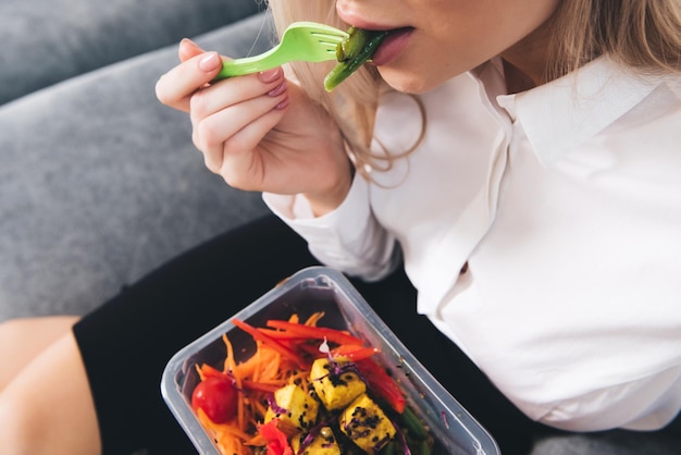 Photo woman eating a meal from a container