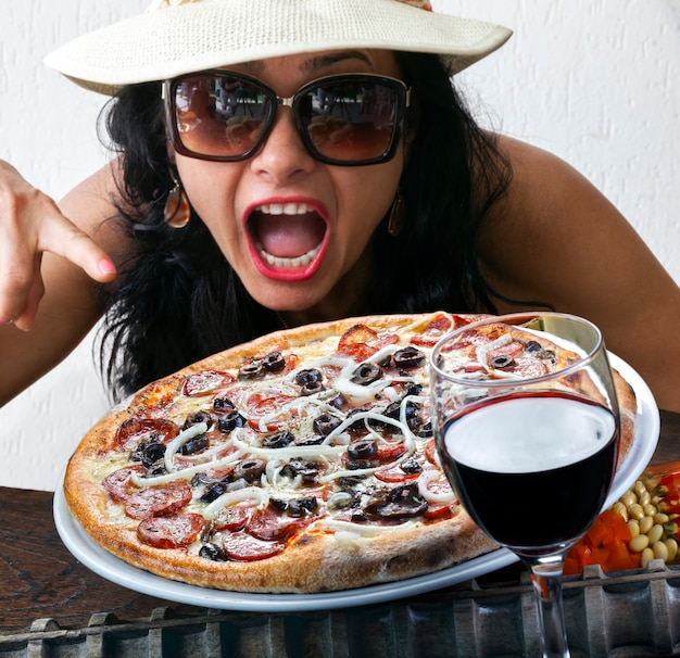 Foto donna che mangia pizza ai peperoni