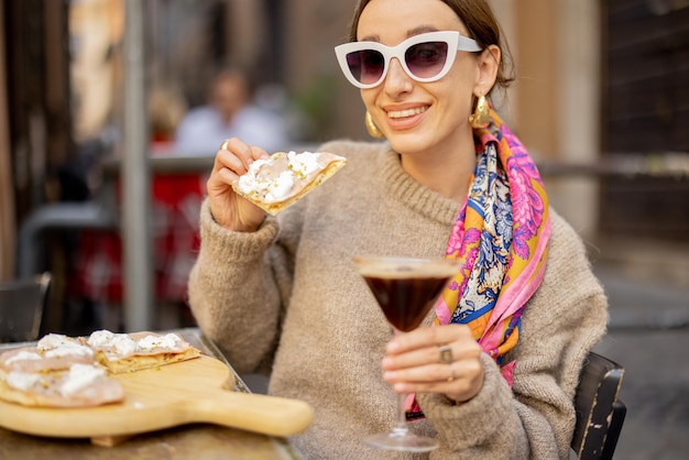Фото Женщина ест пиццу в итальянском ресторане на открытом воздухе