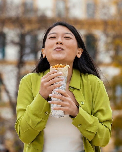 屋台の食べ物を食べる女性