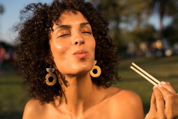 Woman eating sushi in the park