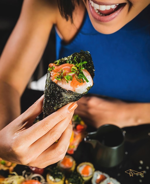 A woman eating sushi at the sushi bar