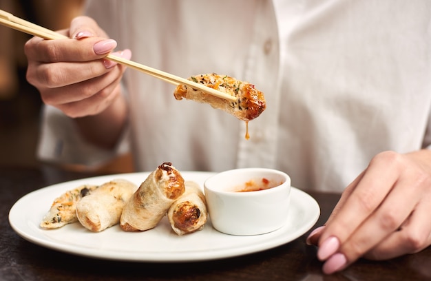 아시아 레스토랑에서 맛있는 동양식 저녁 식사를 하는 여자.