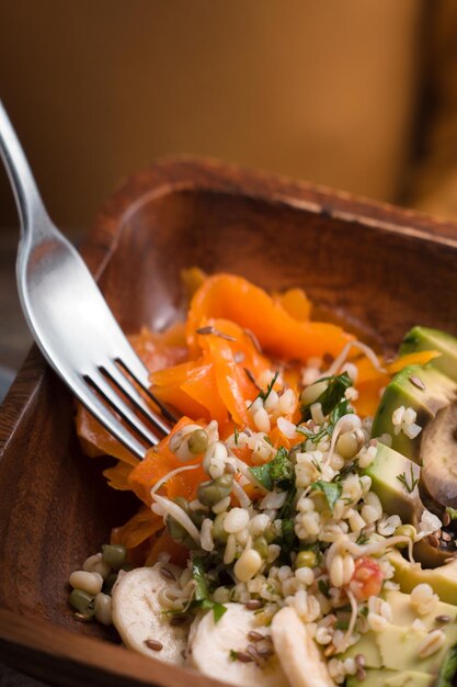 Woman eating with a fork Salad of pumpkin avocado banana vertical