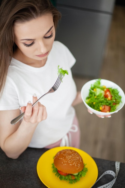 Woman eats a diet salad the concept of weight loss and dieting